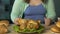 Plump lady sharpening knife against fork, getting ready to eat big roast chicken