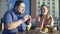 Plump man and woman eating burgers and fries, colleagues having lunch outside