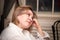 A plump pretty middle aged woman with blonde hair resting in a room by herself