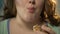 Plump woman biting donut and chewing it, overeating sweet pastry, face closeup