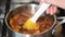 Plums boil in syrup during the preparation of plum jam.