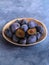 Plums in a bright bamboo bowl on a blue background