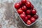 Plums in a plastic carton container on a grunge background.