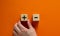 Plus or minus. Businessman holds a cubes with plus icon. Wooden cube with minus icon. Beautiful orange background. Copy space.