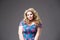 Plus size fashion model in floral dress, fat woman on gray background