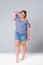 Plus size fashion model in jean shorts, fat woman on gray background
