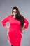 Plus size fashion model in red dress, fat woman on gray background, body positive concept