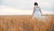 Plus size fashion model in slow motion video walking white dress on field wheat. lifestyle fat woman on nature in the