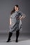 Plus size fashion model in striped dress, fat woman on gray background, overweight female body