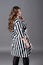 Plus size fashion model in striped dress, fat woman on gray background, overweight female body