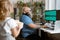 Plus size man with headphones works on computer while girl holds gift box in room