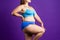 Plus size model in blue lingerie, fat woman with thick thigh on purple background