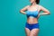 Plus size model in blue underwear on turquoise background