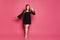 Plus size model girl in black gown makes step up on the pink background