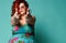 Plus-size overweight redhead lady in sunglasses shows a gesture sign finger - gun, aimed at us at free text copy space on mint