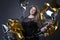 Plus size woman in black dres with balloons on gray background