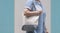 Plus size woman carrying reusable canvas eco friendly tote bag on pastel blue and gray wall outside of supermarket
