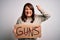 Plus size woman holding stop guns cardboard banner warning about violence annoyed and frustrated shouting with anger, crazy and