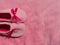 Plush baby's bootees pink velvet fabric texture top view. Smooth soft fluffy velvety satin cloth girly shiny rose female