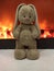 Plush beige Bunny on the background of the fireplace
