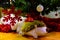 Plush hedgehog carrying presents under a christmas tree