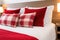 plush pillows on a neat double bed covered in red