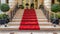 a plush red carpet cascades down the stairs, adorning the interior of a lavish hotel or restaurant, exuding elegance and