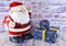 Plush Santa Claus stands next to New Year\\\'s gifts