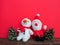 Plush sewn Christmas soft toys on a red background. Painted cones. A little smiling snowman and a funny Santa