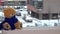 Plush teddy bear with blue scarf sitting on radiator near window. Snow falling