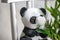 Plush toy panda, green bamboo plant in a pot on a white chair. Small plants in a vase to decorate the house and office