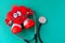 Plush toy in the shape of a heart,the stethoscope in the ears ,on the background of Aqua Menthe