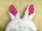 Plushy toy bunny rabbit ears. Happy easter concept. Yellow background. Easter minimal concept Picture with space for your text