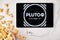 Pluto TV on the screen of the tablet with popcorn box and Apple earphones on the background. Advertising or news content