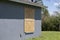 Plywood mounted as storm shutters for hurricane protection of house windows. Protective measures before natural disaster