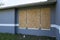 Plywood storm shutters for hurricane protection of house windows. Protective measures before natural disaster in Florida