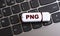 PNG - the word on a white flash drive, lying on a black laptop keyboard