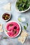 Pnk beet hummus spread or dip with mix salad leaves. Healthy raw summer appetizer, vegan, vegetarian snack.