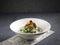 Poached Baby Spinach with Eggs Trio in Superior Broth served in a dish isolated on mat side view on dark background