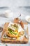 Poached egg with avocado, ricotta cheese and radish sprouts on burger bun. Healthy sandwich with bread, fresh avocado, poached egg