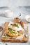 Poached egg with avocado, ricotta cheese and radish sprouts on burger bun. Healthy sandwich with bread, fresh avocado, poached egg