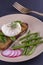 Poached egg on a piece of bread with fried green beans, radish and arugula on a plate