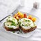 Poached eggs and avocado on toast with tomatoes