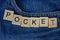Pocket on a blue trouser fabric with the word made of  letters
