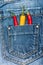 Pocket of jeans staffed with red and yellow chilly peppers, denim background. Peppers in back pocket of blue jeans. Hot