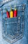 Pocket of jeans staffed with red and yellow chilly peppers, denim background. Piquant secret in pocket of pants, top