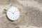 Pocket watch buried in sand