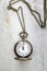 Pocket watch with chain on marble.