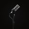 Podcast microphone on a tripod, a black metal dynamic microphone, isolated black background, recording podcast or radio program, s