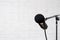 Podcast, voice recording and blogging concept - modern microphone over white brick wall background